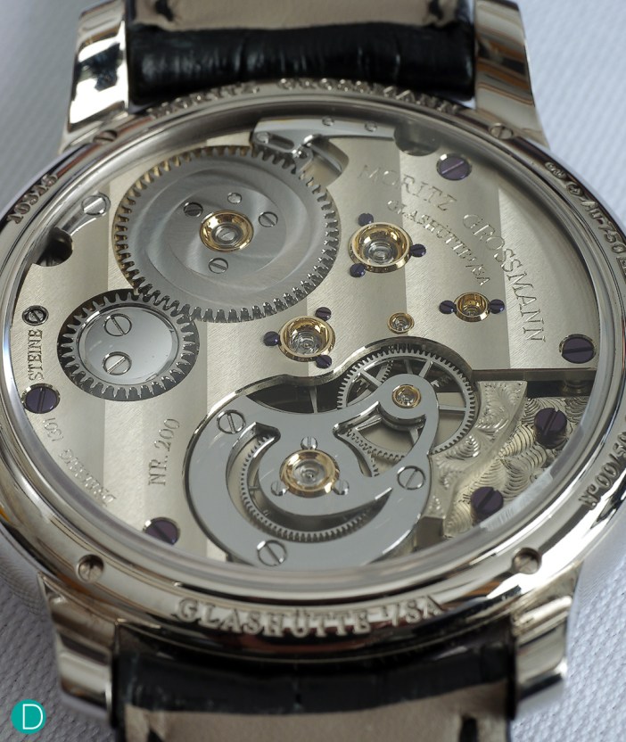 The caliber 103.0 in unfinished German Silver, but with the gear train in ultra modern ARCAP. The movement is finished with wide Glashütte ribbing, and hand engraved details.